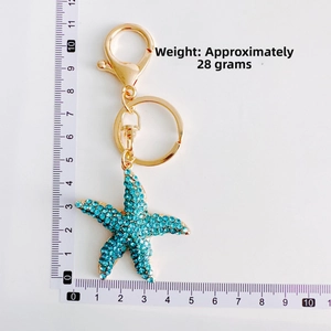 Detailed size view of gold starfish keychain with blue rhinestones and dimensions shown