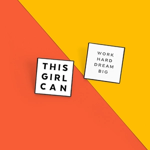 Macro view of square enamel badges with slogans This Girl Can and Work Hard Dream Big