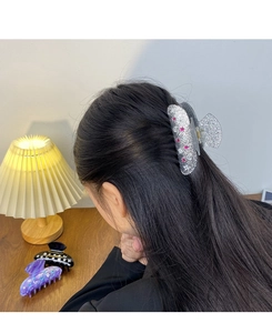 Detailed view of glittering hair claws with star and moon patterns in multiple colors