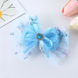 Blue glitter bow hair clip with heart-shaped gemstone and snowflake mesh detail