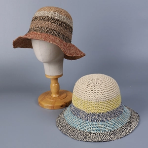Detail of wide brim straw hats with colorful stripes on a wooden display stand