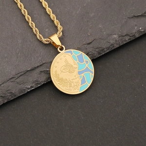 Detail of gold twisted chain and dual-design pendant with blue enamel and face relief