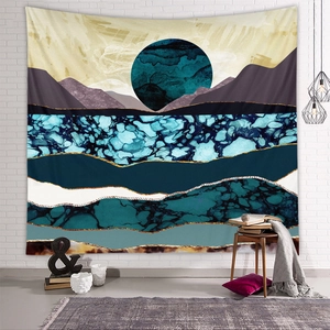 Detail of mountain tapestry with abstract sun and gold lines on a white brick wall