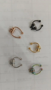 Set of 5 non-pierced magnetic nose rings in various colors on grid background