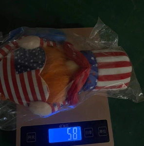Close-up of patriotic gnome plush weighing 58g on scale for American Independence Day