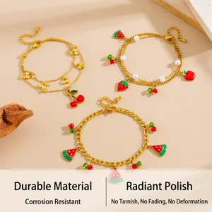 Gros plan des breloques fraise cerise et pastèque sur des bracelets en or plaqué