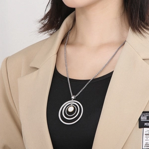 Close-up of silver multi-layer concentric ring pendant with sparkling crystal inlay