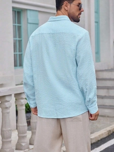 Close-up of light blue seersucker plaid shirt fabric texture on man's back