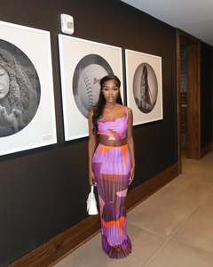 Detail of colorful pleated two-piece set featuring a crop top and high waist long skirt