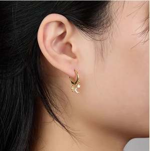 Close-up of gold S925 silver hoop earrings with star, moon and cross charms