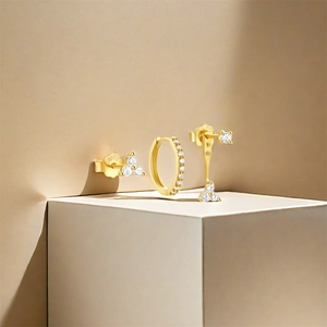 Detail of three-piece gold S925 sterling silver earring set with sparkling zircon stones