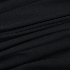 Macro shot of black knit fabric texture showing the drape and fine weaving of the dress