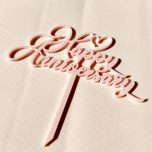 Pink acrylic Happy Anniversary cake topper with heart design for wedding celebration