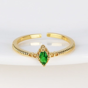 Macro view of vintage gold ring with marquise-cut green stone and twisted rope band