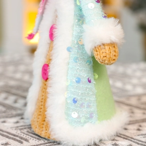 Macro view of Christmas plush doll showing sequin fabric, knit texture and soft faux fur