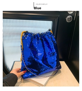 Close-up of bright blue sequin bucket bag with yellow drawstring and gold chain strap