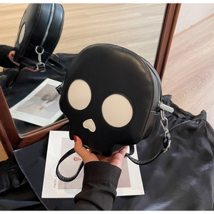 Detailed close-up of a black skull-shaped crossbody bag with white heart nose and eyes