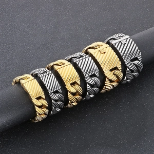Close-up of gold and silver chunky Cuban chain bracelets with textured square clasps