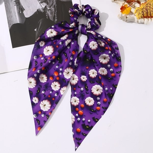 Détail d'un chouchou d'Halloween avec citrouille et chauve-souris sur satin violet