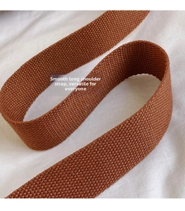 Close-up of a brown woven shoulder strap featuring premium braided texture and glossy finish