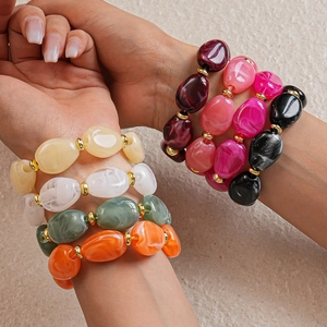 Macro shot of colorful chunky acrylic resin irregular bead bracelets with gold accents
