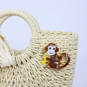 Handmade straw bag with lace handles and a cute acrylic monkey with banana accessory
