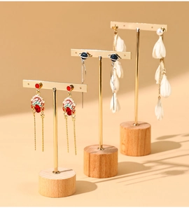 Three-piece jewelry display set with gold metal hangers and round wooden bases for earrings