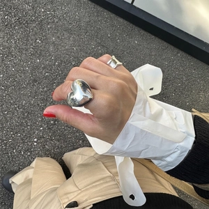 S925 sterling silver heart ring and irregular wave band on hand in natural light