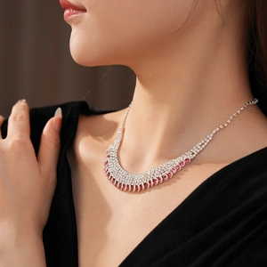 Detailed view of silver necklace with pink and clear rhinestones on model neck