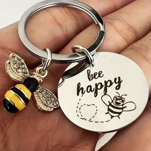 Macro shot of stainless steel keychain with bee pendant and bee happy engraved charm