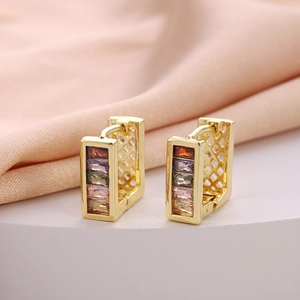 Detail view of gold hoop earrings with multi-colored rectangular zircon stones and side carvings