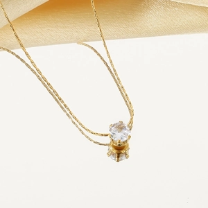 Collier élégant en or avec zircon et six griffes sur soie beige avec reflet chic