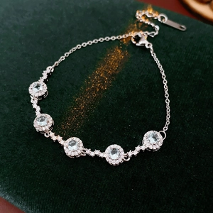 Vue macro d'un bracelet en argent avec cinq zircons bleu marine sur support en velours vert