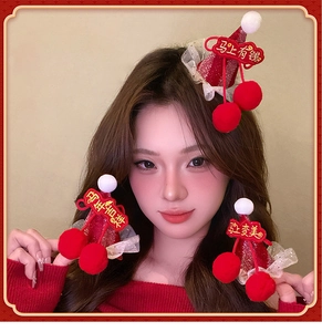 Close-up of red festive mini hat hair clips with white plush balls and embroidery