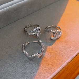 Detailed macro view of silver zircon rings with heart, drop, and cross shapes
