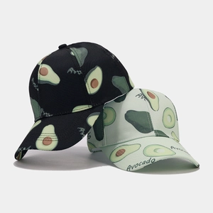 Close-up of black and light green baseball caps with tropical avocado pattern print