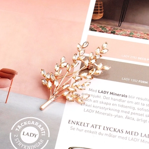 Macro view of golden wheat stalk brooch with sparkling crystals on a magazine
