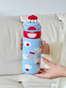 Gros plan d'un enfant tenant un thermos éléphant avec paille et couvercle double