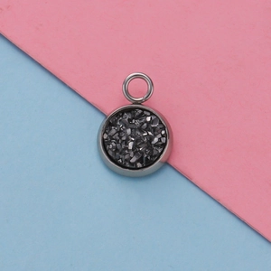 Macro shot of 12mm silver stainless steel round pendant with dark textured crystal inlay