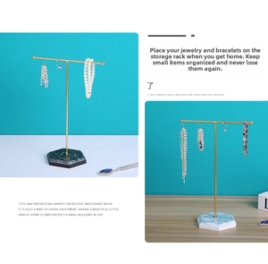 Detail of T-bar jewelry display rack with hexagonal marble base and golden metal frame