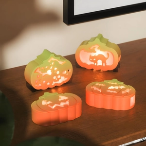 Close-up of Halloween hollow pumpkin LED lights with a warm yellow glow on a wooden desk