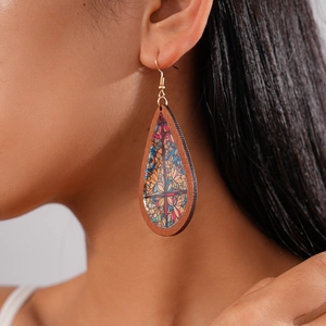 Close-up of bohemian wooden teardrop earrings with floral print on a model