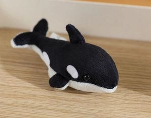 Macro detail of plush orca finger puppet with soft black and white fabric texture