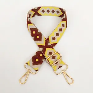 Detail of adjustable woven bag strap with ethnic diamond pattern and gold hardware