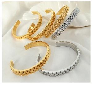 Close-up of gold and silver plated titanium steel bangles with gear texture detail
