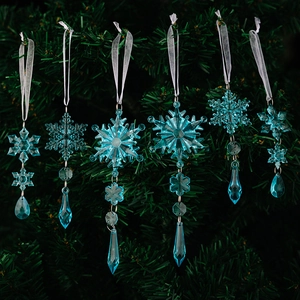 Close-up of 6 blue acrylic snowflake ornaments hanging on a green Christmas tree