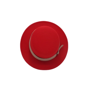 Vista dall'alto di un cappello di lana rosso con cinturino in pelle kaki e fibbia in metallo