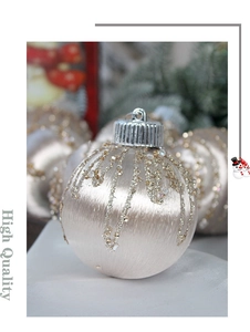 Close-up of an 8cm champagne satin Christmas ball with gold glitter and silver cap