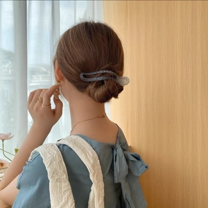 Detail of matte greyish-blue hair claw clip styled in an elegant updo hairstyle