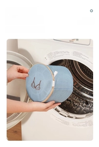 Thickened blue mesh laundry bag for bras shown in front of a washing machine drum
